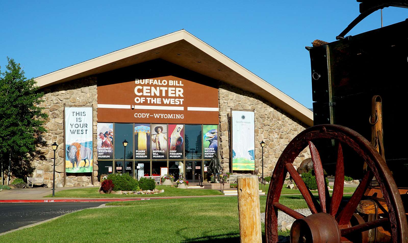 Facade of the Center of the West with part of a chuck wagon's wagon wheel in the foreground on the right side
