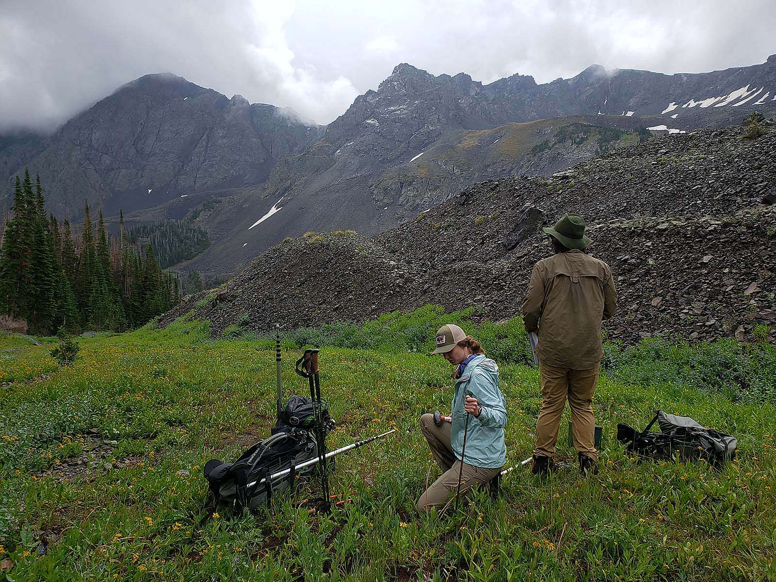 Amy Phillips pounds stake as Jason Riggio takes note of vegetation surrounding mic