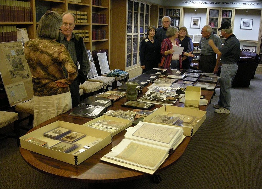 Library staff and advisory board members examine a new acquisition