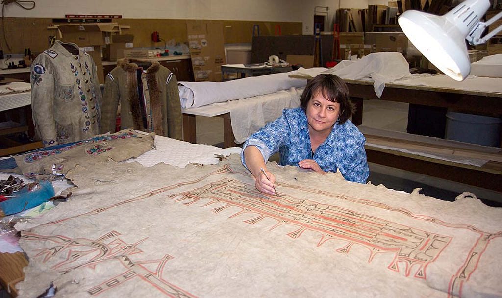 Beverly Perkins treats a painted hide in the Center's conservation lab.