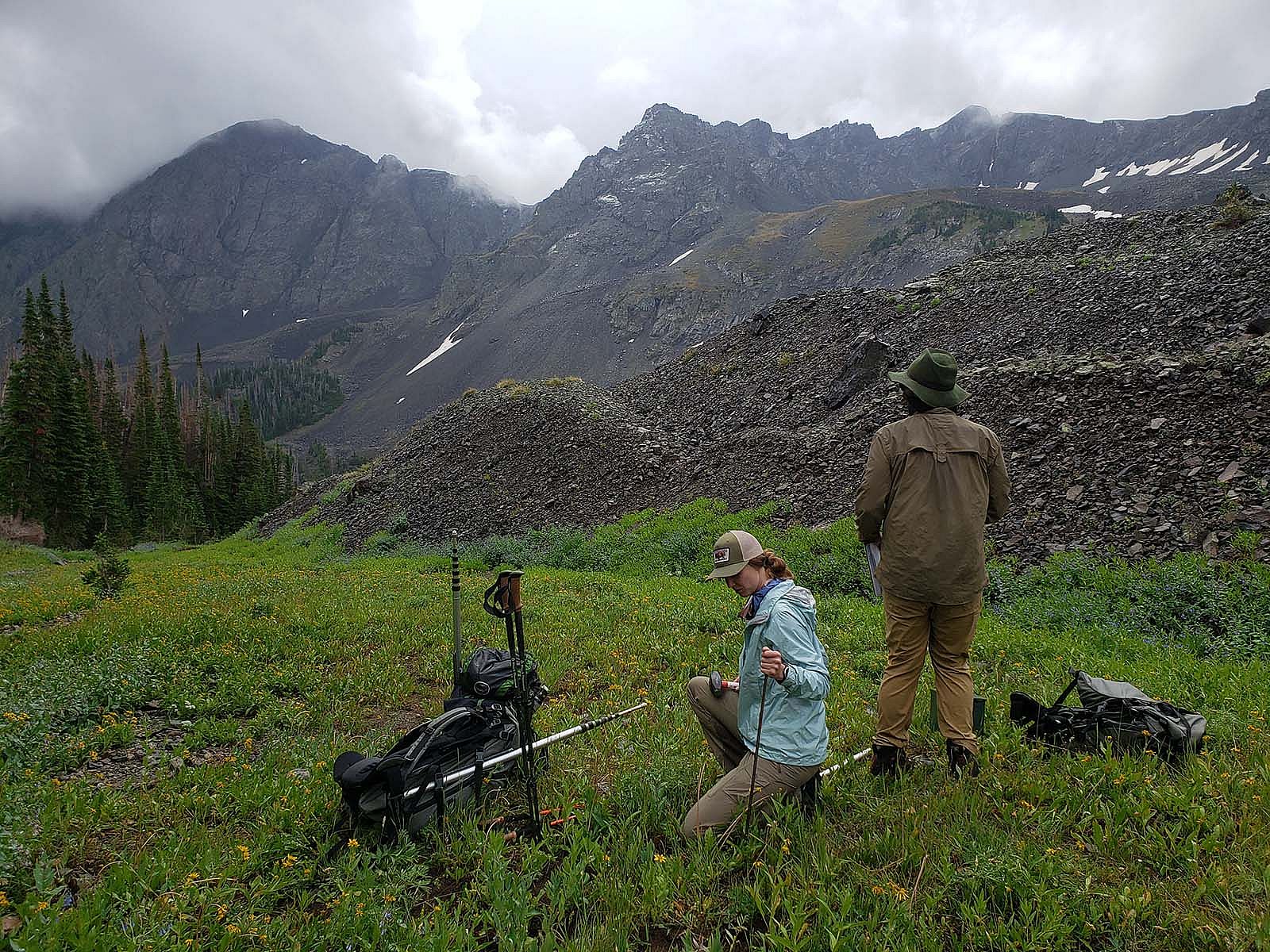 Amy Phillips pounds stake as Jason Riggio takes note of vegetation surrounding mic