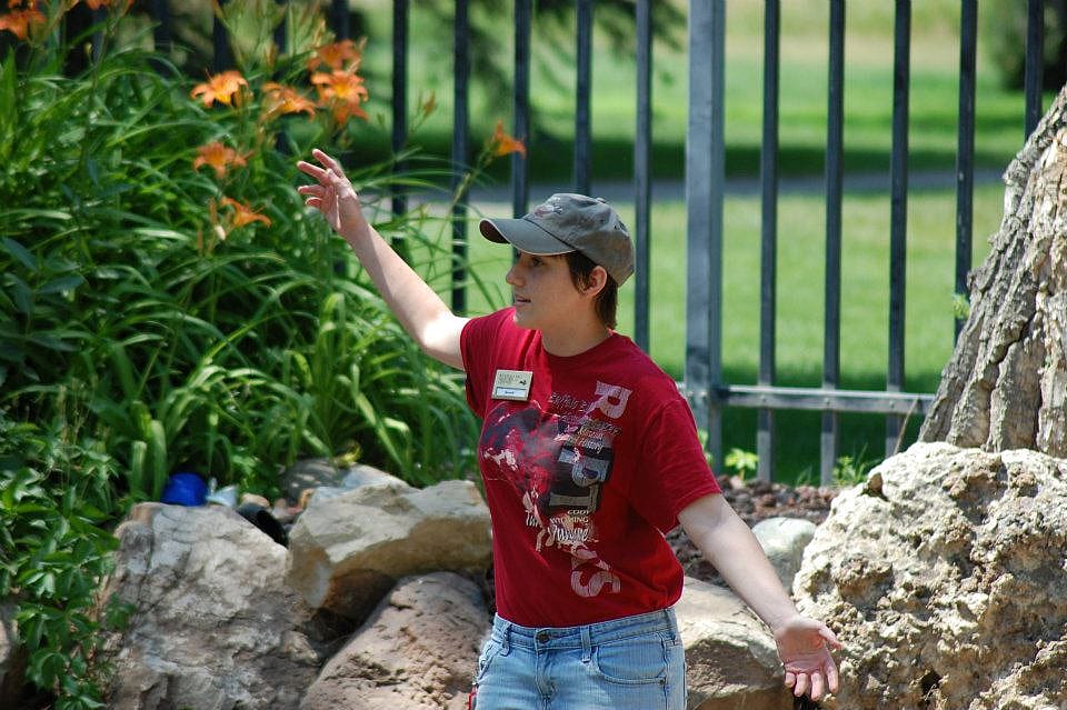 A trainer at the Greater Yellowstone Raptor Experience connecting with the audience by getting in touch with her inner bird.