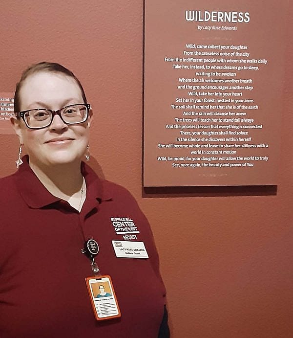 Lacy Rose Edwards standing by her poem, "Wilderness" in the Whitney Wester Art Museum
