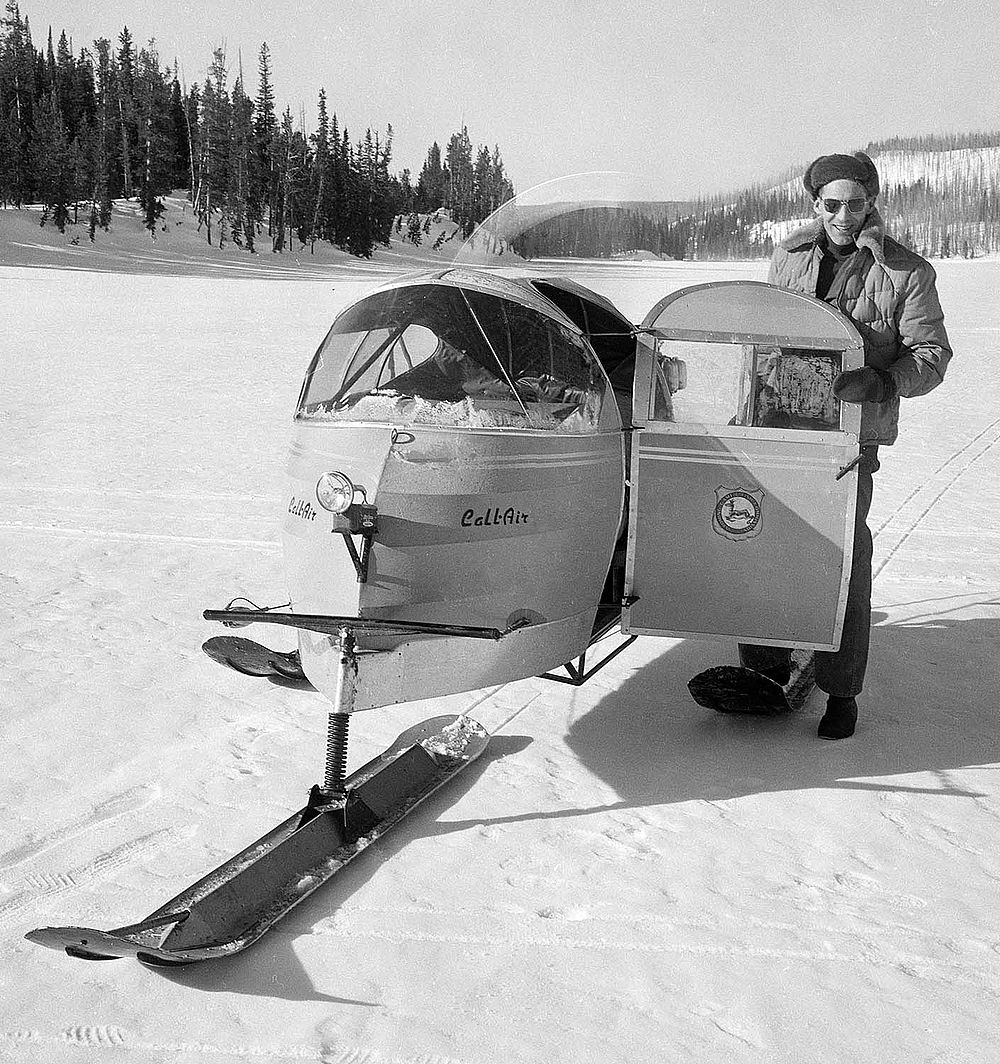 Larry Morrison, editor of the "Cody Enterprise," standing next to a snow plane on the ice at Lewis Lake, 1955. MS 89 Jack Richard Photograph Collection, McCracken Research Library. PN.89.10.1657.12