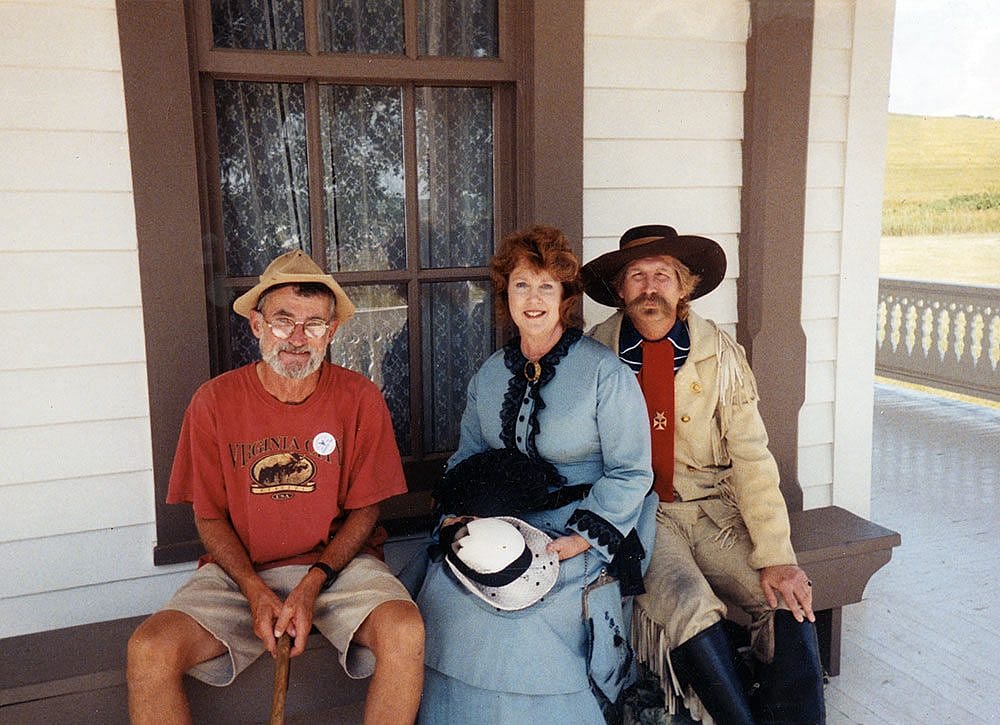 The "Charming Bum," Guy Gertsch (left), visits with Libby and George Armstrong "Autie" Custer outside their reconstructed home at Fort Abraham Lincoln near Bismarck, North Dakota.