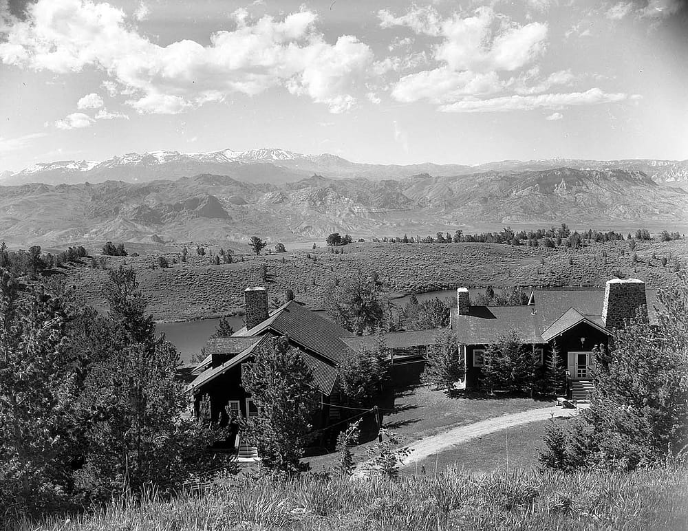 Black & white photograph of Coe Lodge at Irma Lake with mountains on the horizon, before 1938. MS 316 Stan Kershaw Collection. PN.316.1561