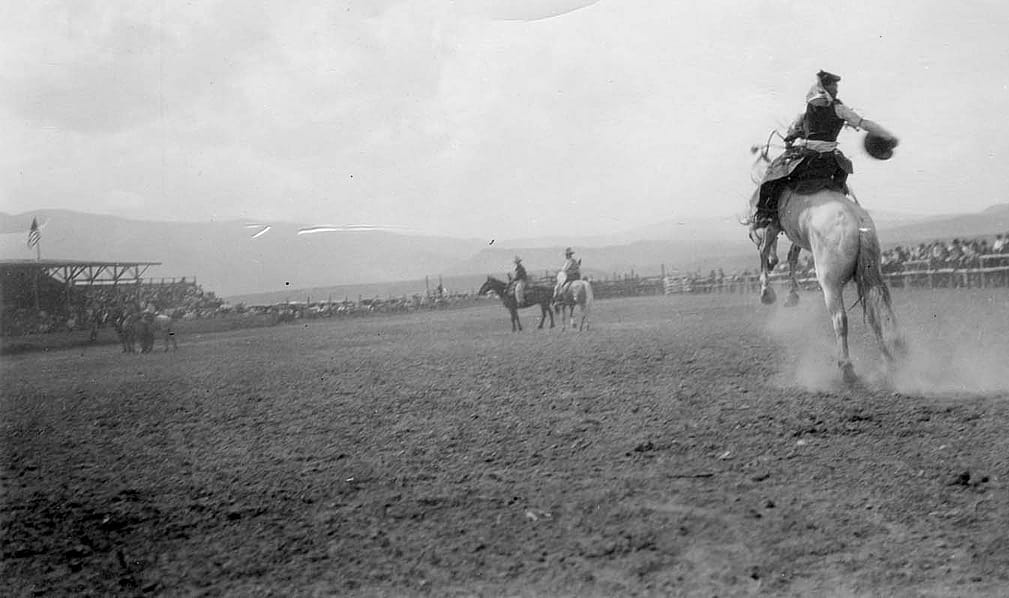 Champion rider and local boy Nick Knight rides at the Cody Stampede, ca. 1935. Grandstands on left. Photo courtesy the Park County Archives. P86-016-12