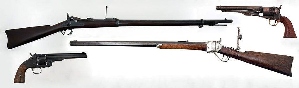 "Cinematically unpopular" favorite firearms of the American West. Clockwise, from top left: M1873 trapdoor Springfield rifle, Gift of Olin Corporation, Winchester Arms Collection, 1988.8.754; M1860 Colt Army revolver, on loan from F.T. Bucholz Collection, L.1.95.11; M1874 Sharps Rifle, Gift of H. Bill Newton, 1990.10.1; and Smith and Wesson Schofield revolver, Gift of the Olin Corporation, Winchester Arms Collection. 1988.8.2534