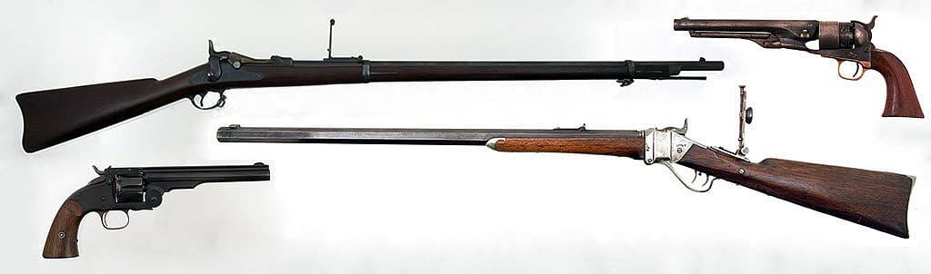 "Cinematically unpopular" favorite firearms of the American West. Clockwise, from top left: M1873 trapdoor Springfield rifle, Gift of Olin Corporation, Winchester Arms Collection, 1988.8.754; M1860 Colt Army revolver, on loan from F.T. Bucholz Collection, L.1.95.11; M1874 Sharps Rifle, Gift of H. Bill Newton, 1990.10.1; and Smith and Wesson Schofield revolver, Gift of the Olin Corporation, Winchester Arms Collection. 1988.8.2534