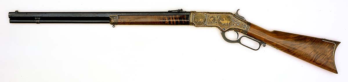 Model 1866 Winchester, ca. 1873. Engraved by master artisan Conrad F. Ulrich featuring an unusual decorative border at the wrist using a Grecian key pattern, and a rare depiction of Diana, goddess of the hunt. Other panels depict elk, deer, bear, buffalo, and rabbit. Exhibited at the Centennial Exposition, Philadelphia, Pennsylvania, 1876. Gift of Olin Corporation, Winchester Arms Collection. 1988.8.3283