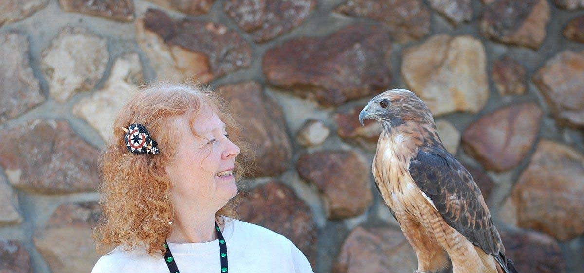 Volunteer Anne with red-tailed hawk Isham.
