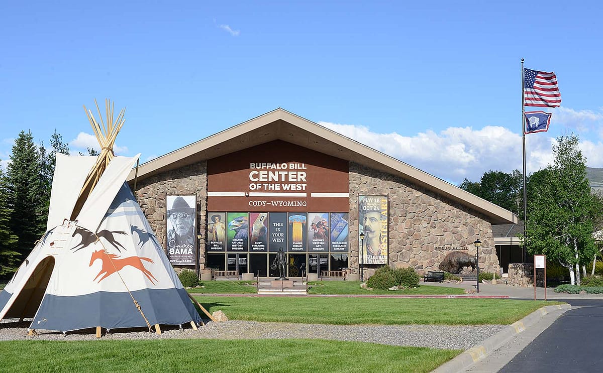 Front view of the Buffalo Bill Center of the West building with tipi and flags.