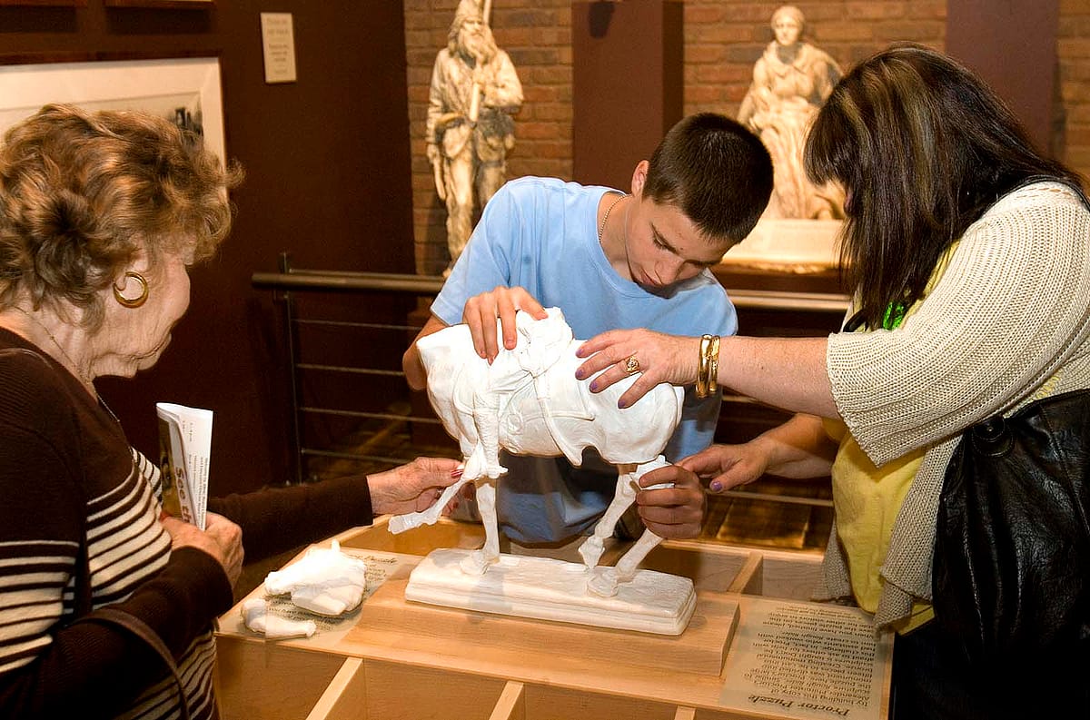 On opening day, visitors try their hands at assembling a model of Alexander Phimister Proctor's monumental sculpture of Teddy Roosevelt, "Rough Rider."