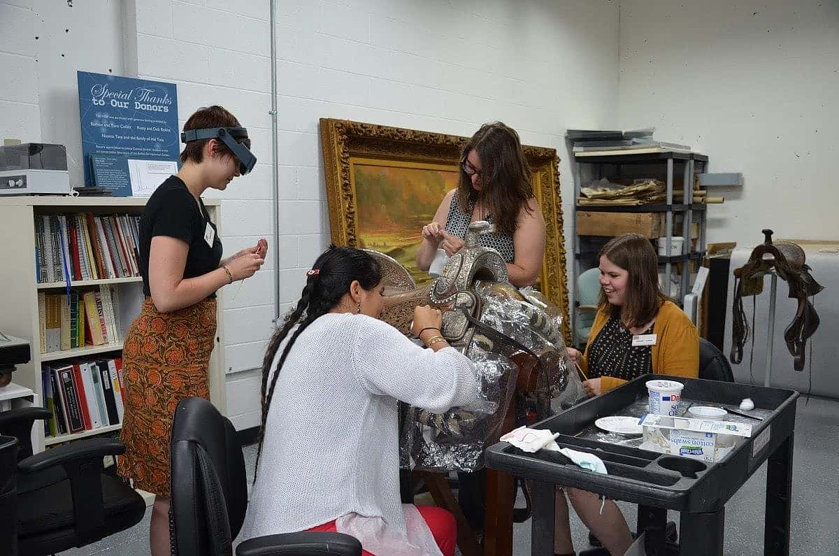 Conservation interns spit cleaning the California Mission saddle. 
