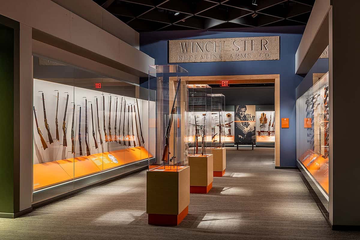 View of Cody Firearms Museum with "Winchester" lintel above displays of firearms.