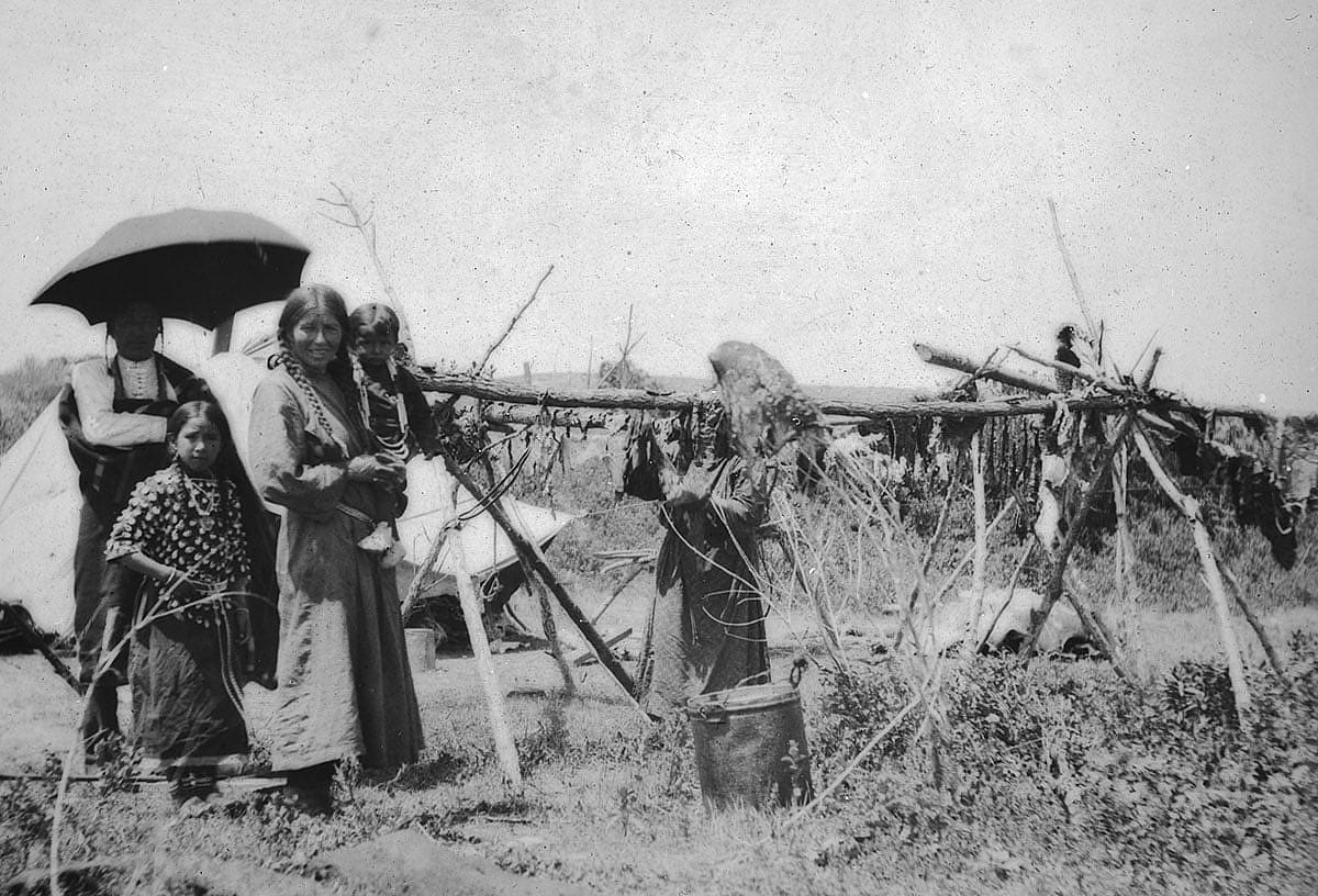Native family in camp with meat hanging to dry, ca. 1903-1925. MS 95 William A. Petzoldt Lantern Slide Collection. LS.95.399