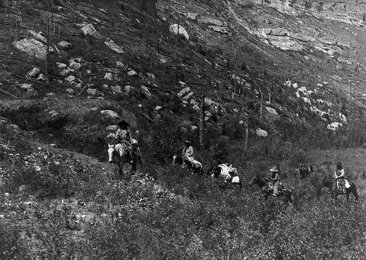 Crow people on horses in canyon, ca. 1903-1925. MS 95 William A. Petzoldt Lantern Slide Collection. LS.95.197