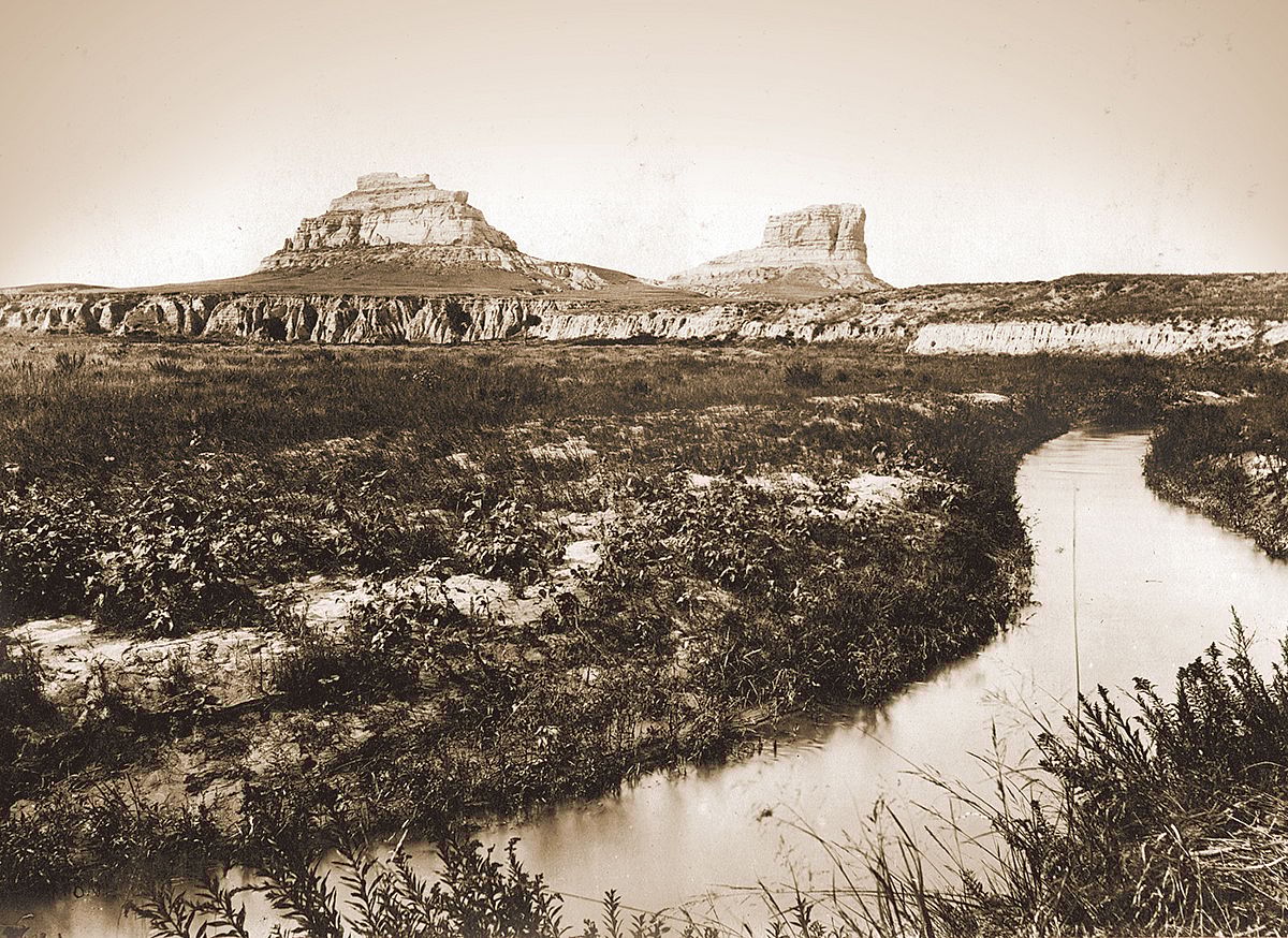 Courthouse and Jail Rocks from the south, Courthouse Rock irrigation canal in the foreground. Cheyenne County, Nebraska, 1897. Plate 4 in U.S. Geological Survey. Professional paper 17. 1903.