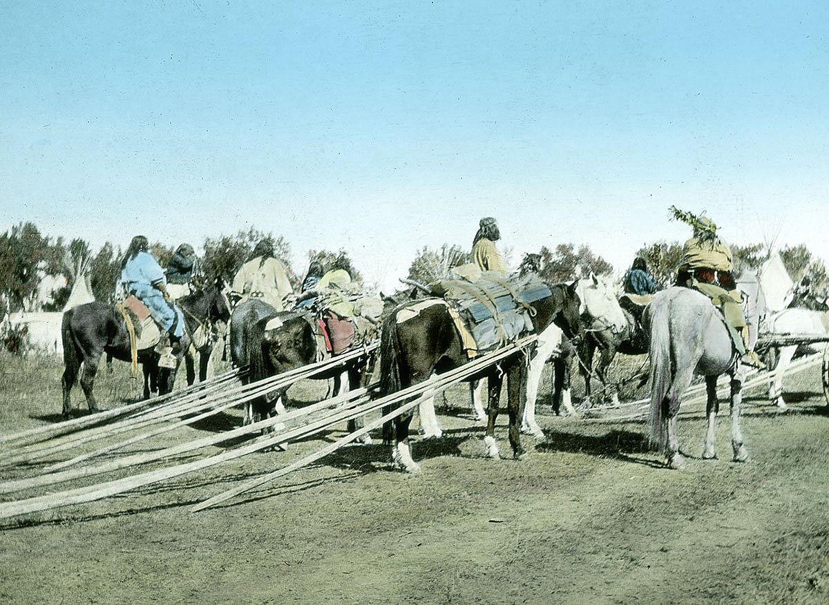 Several Crow people on horseback dragging tipi poles, ca. 1903-1925. MS 95 William A. Petzoldt Lantern Slide Collection. LS.95.294