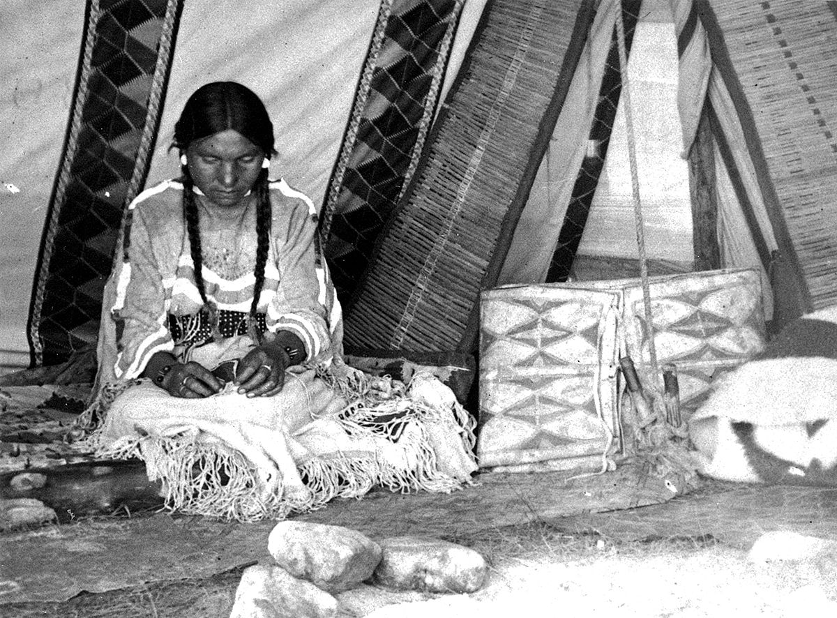 American Indian woman in tipi with parfleche to her left, ca. 1880-1900. MS 35 North American Indian Photograph Collection. P.35.47