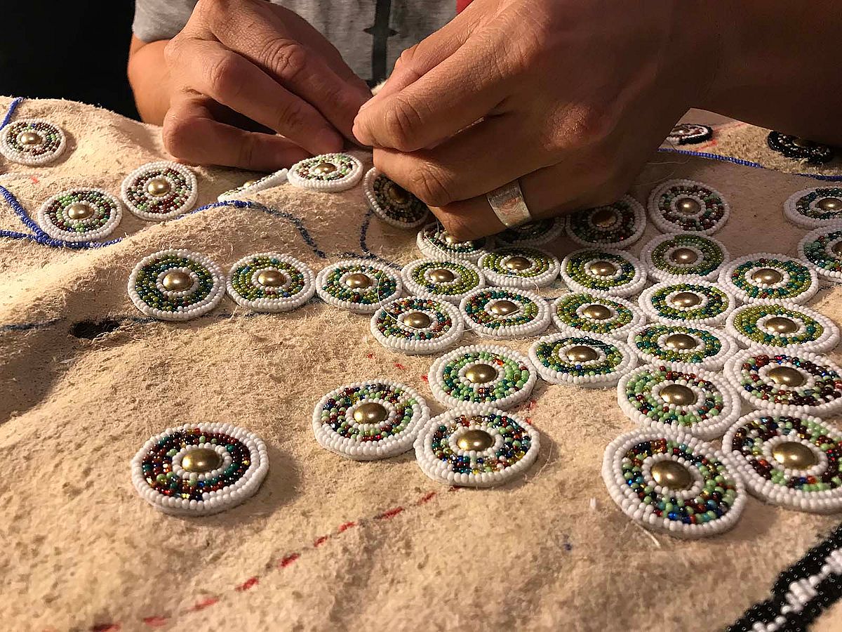 Artist Colleen Friday working on an elk hide art piece.