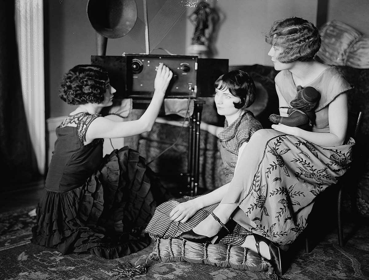 Fig. 10: The last word in 1920s cool! Three fashionably dressed flappers listen to a state-of-the-art home radio. Station WJZ out of Newark, New Jersey, broadcast Harold McCracken's talks about Alaska via clunky home sets like this. Library of Congress Prints and Photographs Division Washington, D.C. 20540 USA. LC-DIG-ggbain-37038