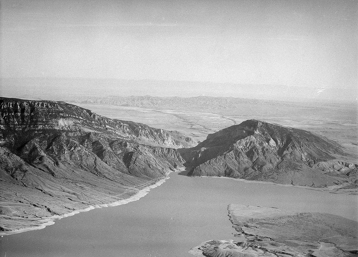 Aerial view of Buffalo Bill Reservoir with Rattlesnake Mountain on left and Spirit (Cedar) Mountain on right. McCullough Peaks and Big Horn Mountains in background. MS 89 Jack Richard Photograph Collection. PN.89.8.1499.13