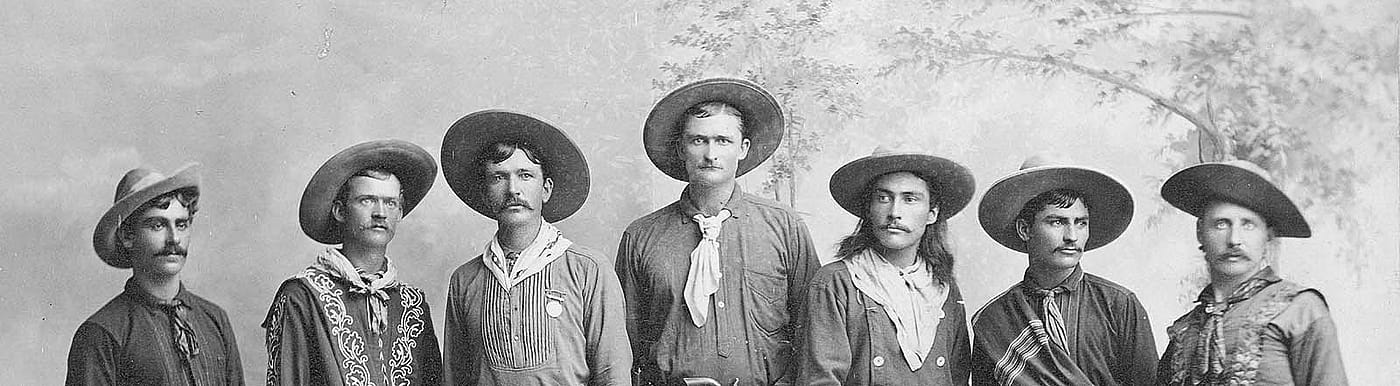In this ca. 1886-1887 photograph, nine cowboys from Buffalo Bill's Wild West show are pictured in their western finery. MS 6 William F. Cody Collection, McCracken Research Library. P.6.86 (detail)