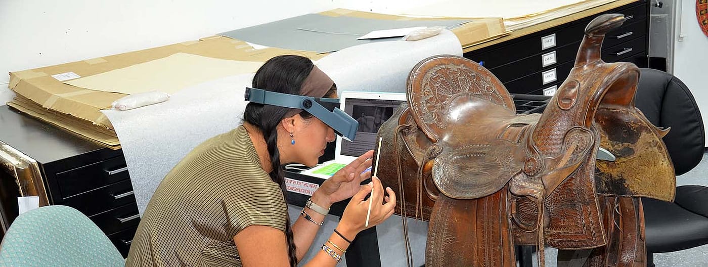Conservation intern Vanessa Ocana-Mayor working on a saddle