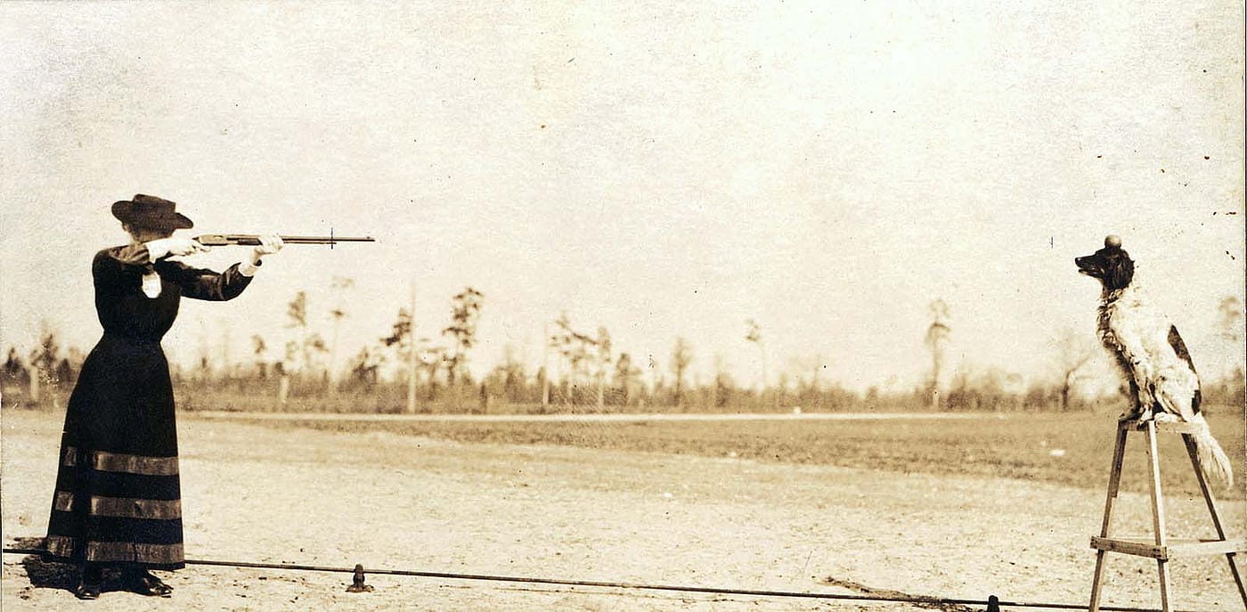 Annie Oakley plans to shoot an apple off the head of her dog Dave in this postcard image. P.94.1