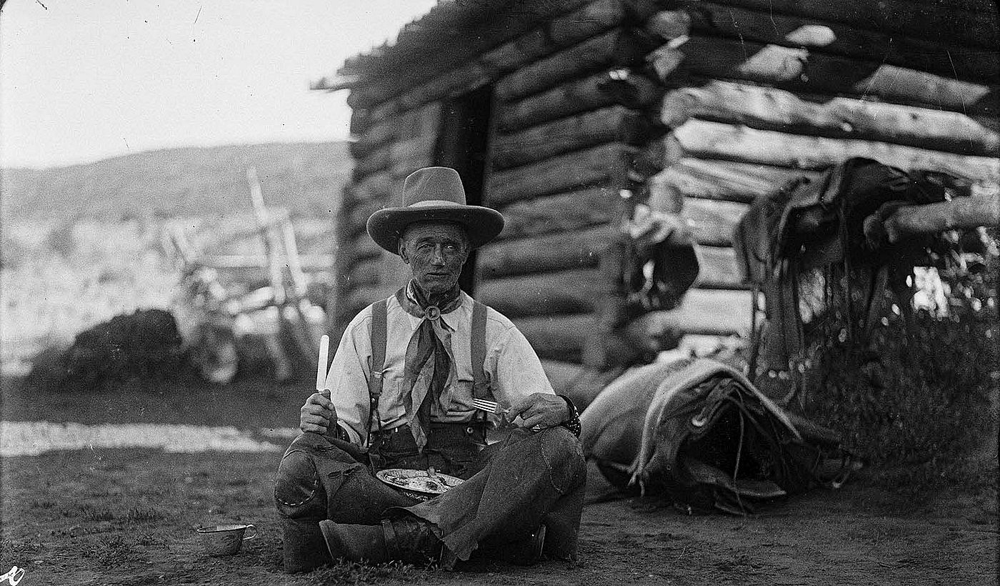 Old Charlie Collins looks a bit "worse for wear" with his tin plate of trail vittles, ca. 1920. Charles Belden black and white glass plate negative. Gift of Mr. and Mrs. Charles Belden. PN.67.39 (detail)