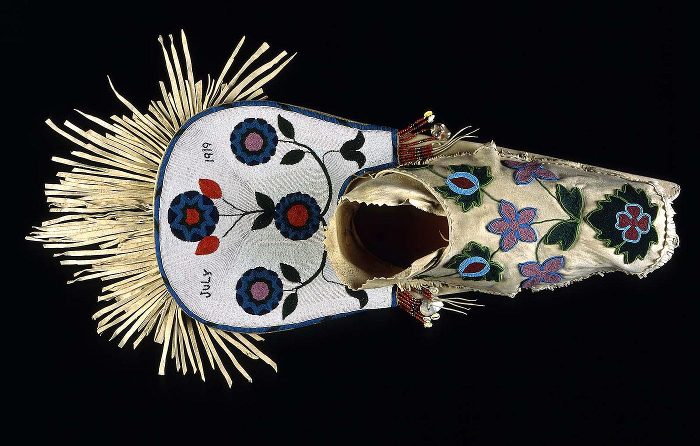 Cradleboard, Salish, Plateau 1919. Wood, tanned hide, muslin, glass beads, cowrie shells, abalone shells, mother of pearl, brass Simplot Collection, Gift of J.R. Simplot; NA.111.57