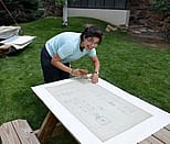 2013 Conservation Intern Josefina Moldonado cleans blueprints from the Cody Firearms Museum