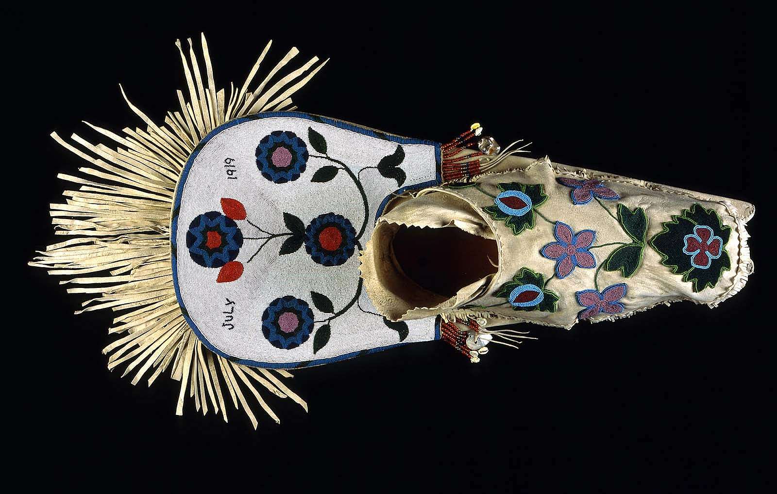 Cradleboard, Salish, Plateau 1919. Wood, tanned hide, muslin, glass beads, cowrie shells, abalone shells, mother of pearl, brass Simplot Collection, Gift of J.R. Simplot; NA.111.57