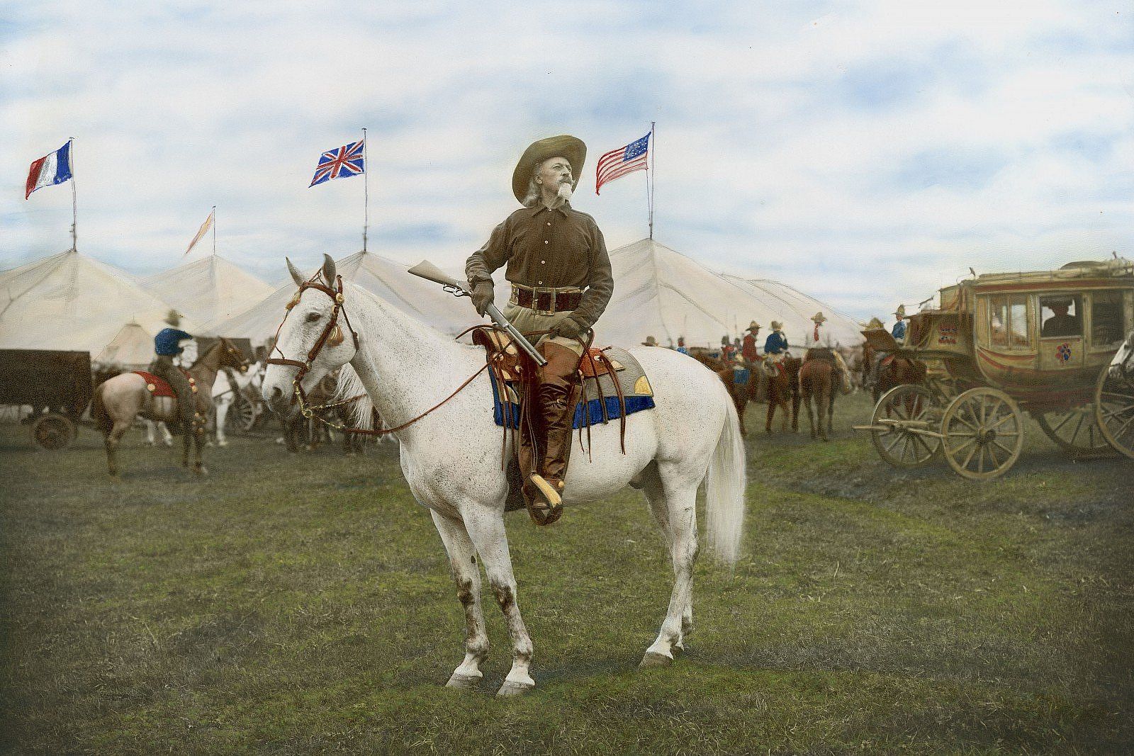 Hand-colored photograph, William F. "Buffalo Bill" Cody on horseback in front of Wild West show tents, ca. 1906 - 1916. MS 6 William F. Cody Collection, McCracken Research Library. P.69.0082 (BBCW-WFC03-P.69.0082)