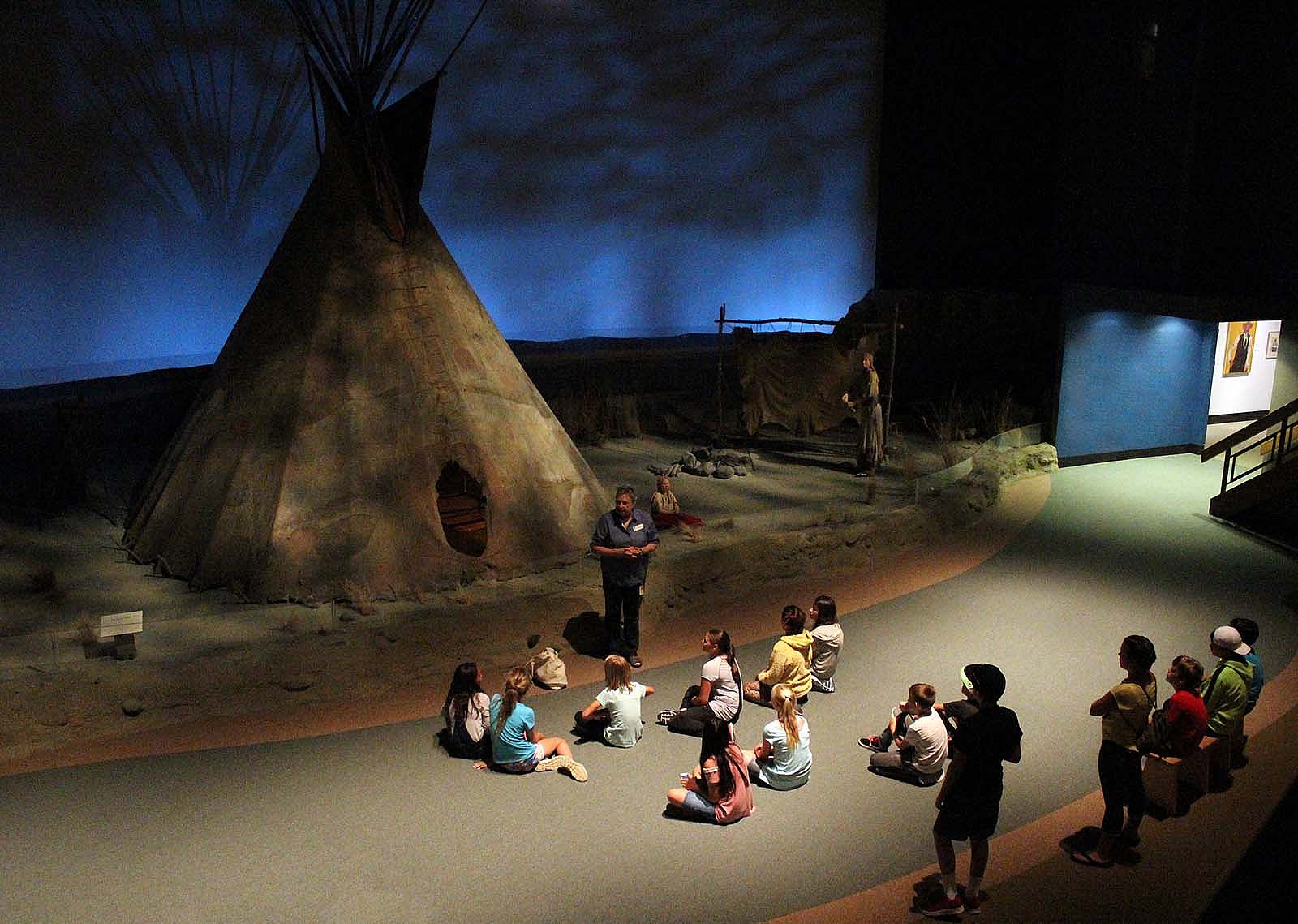 A tour guide and class of students gather in the "Seasons of Life" gallery on the Plains Indian Museum.