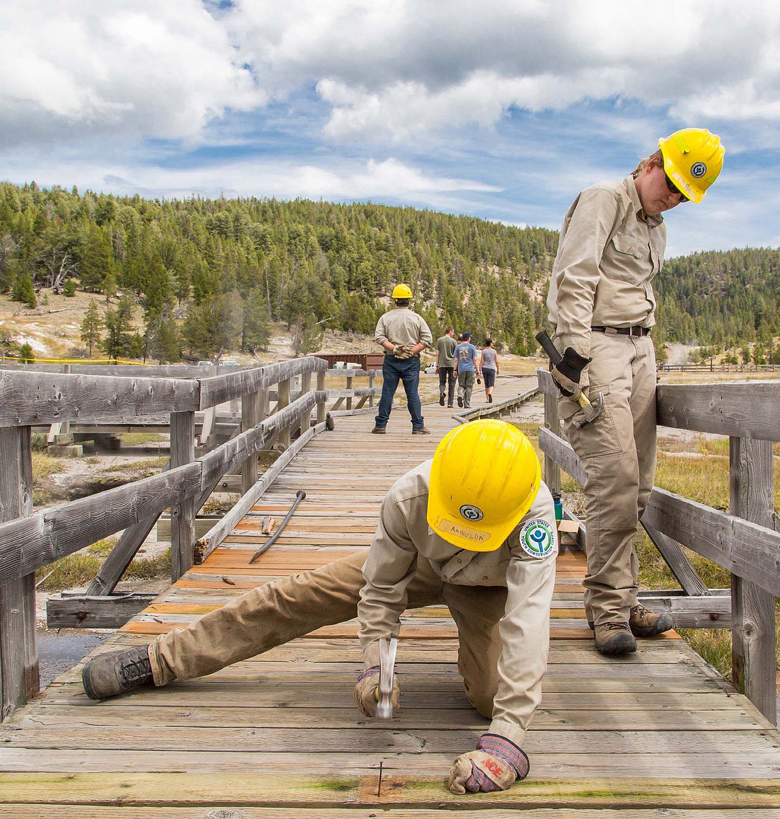 Youth Conservation Corps volunteers replace bridge planks. NPS photo/Neal Herbert.