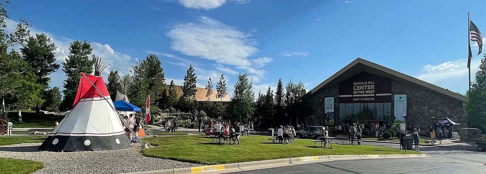 Visitors enjoying the front lawn at the Buffalo Bill Center of the West on a sunny day.