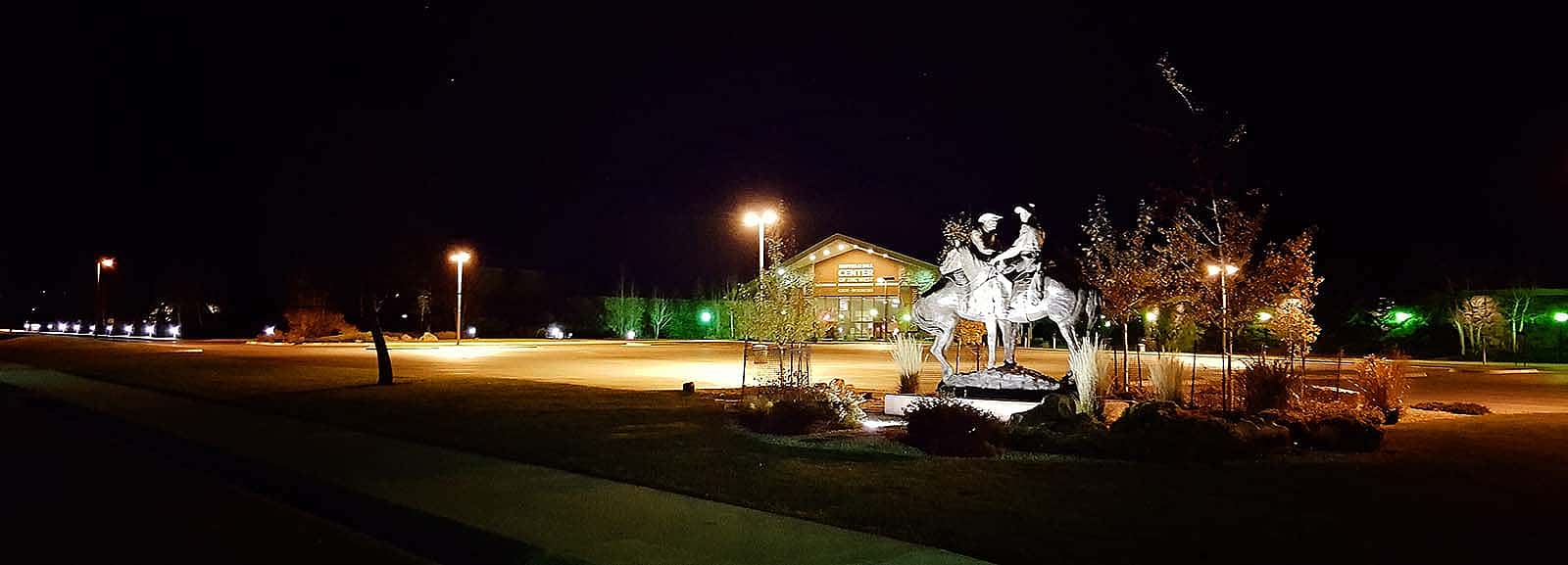 Code of the West sculpture at night