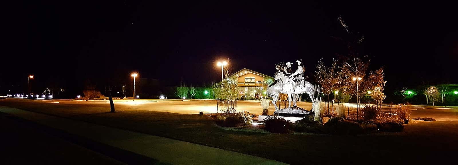 Code of the West sculpture at night