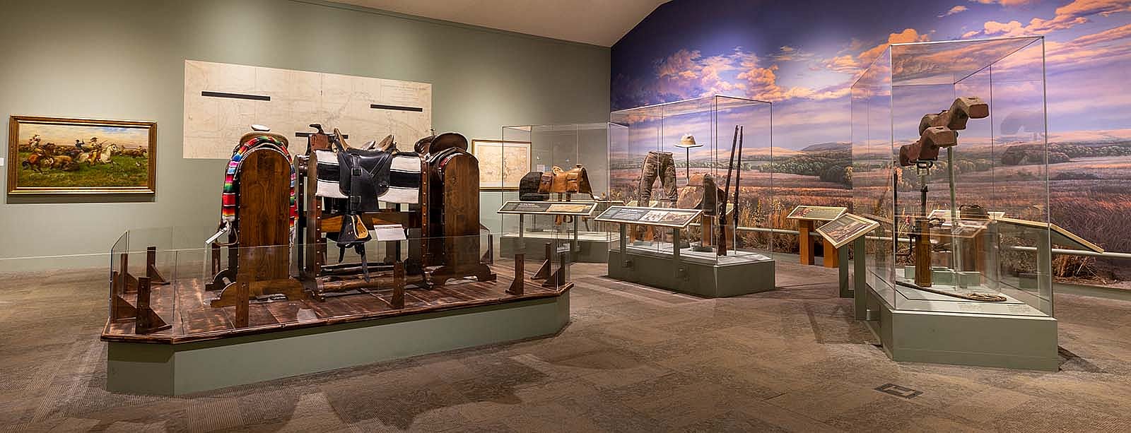 Buffalo Bill Museum, view of artwork on the wall, saddle display, frontier accoutrements.,