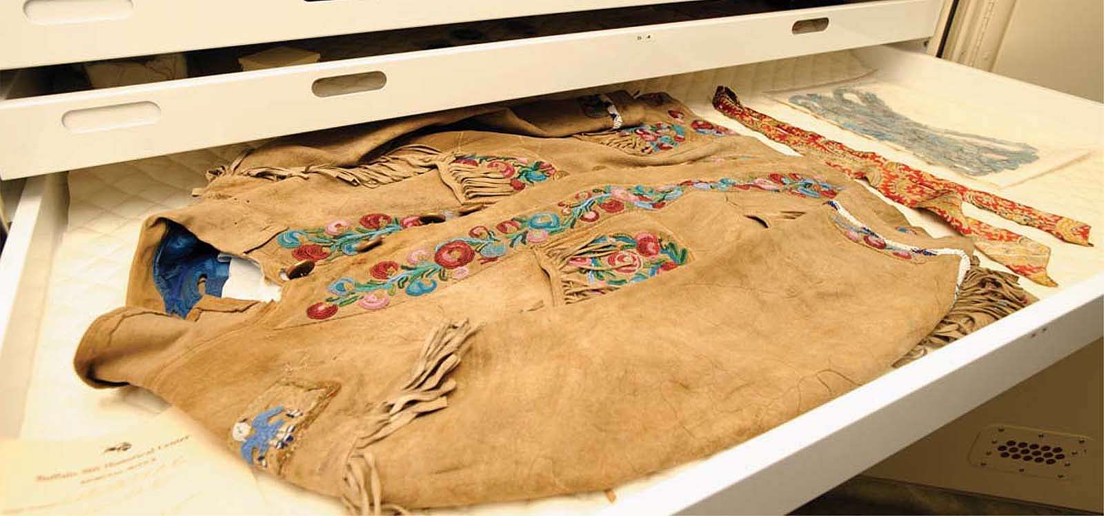 A jacket owned by William F. "Buffalo Bill" Cody in the Buffalo Bill Museum vault. Made of buckskin with brass buttons, beads, and silk satin, ca. 1898. Gift of Robert Garland. 1.69.784