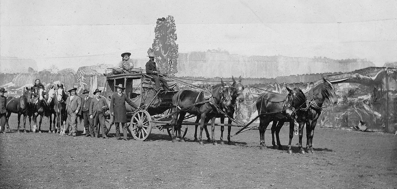 Buffalo Bill, with hand on wheel, and Major Burke, holding the first horse behind the coach, pictured with Wild West show personnel and the Deadwood Coach, ca. 1890. MS 6 William F. Cody Collection, McCracken Research Library. P.69.89