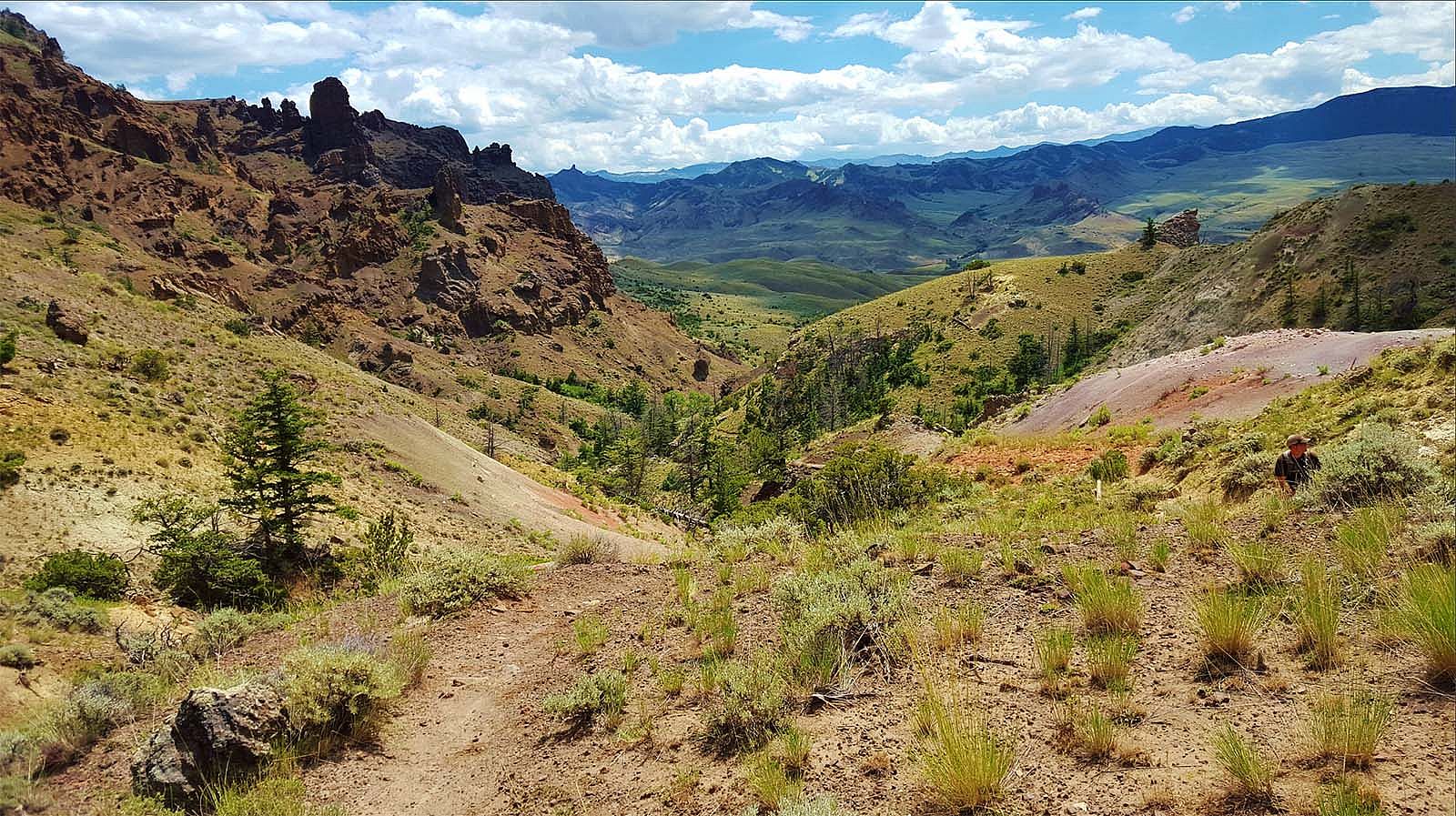 Landscape of mountains, trail, and sky. BLM photo; Creative Commons.