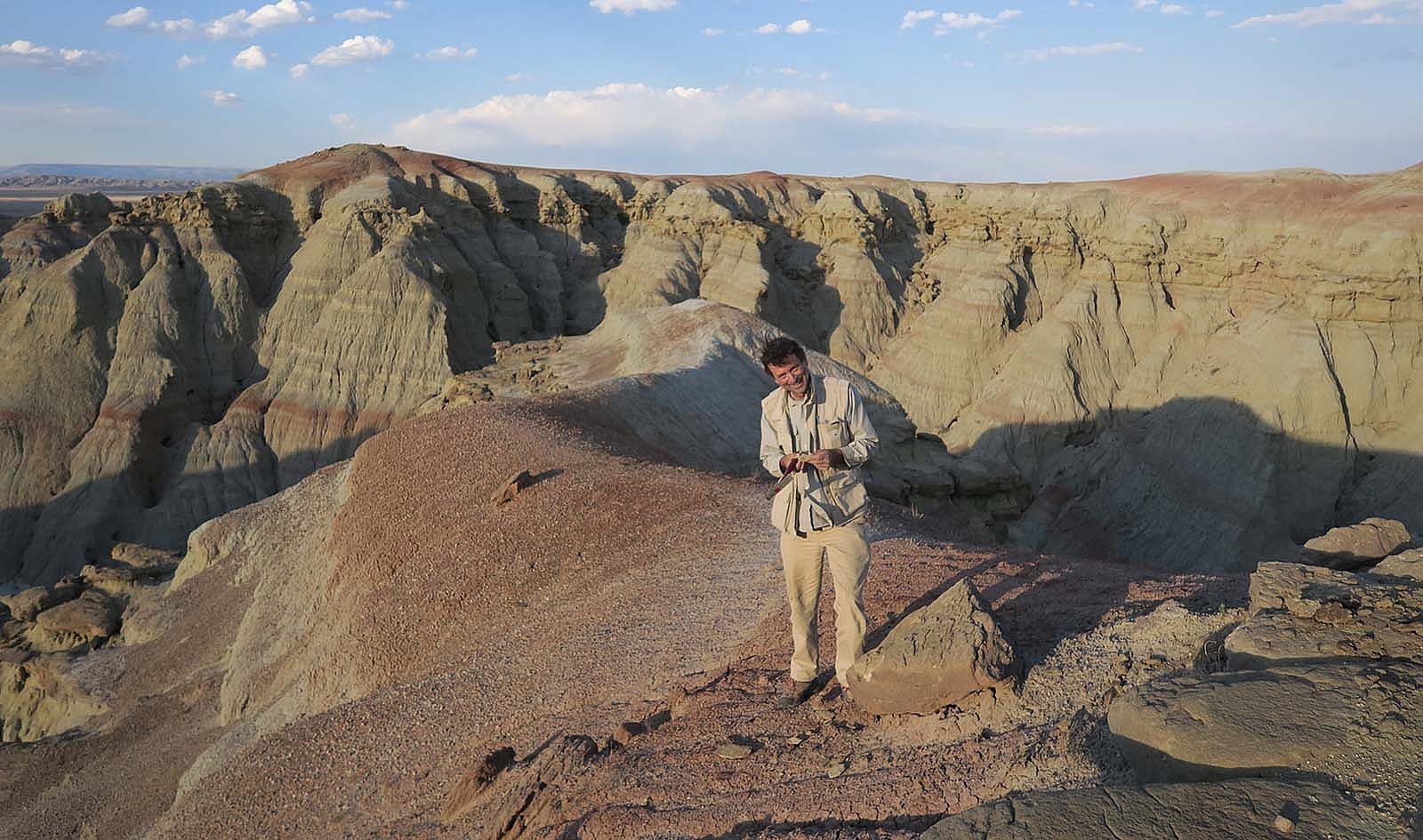 Scott Wing on a badland hill exposing rocks deposited 56 million years ago during the PETM.
