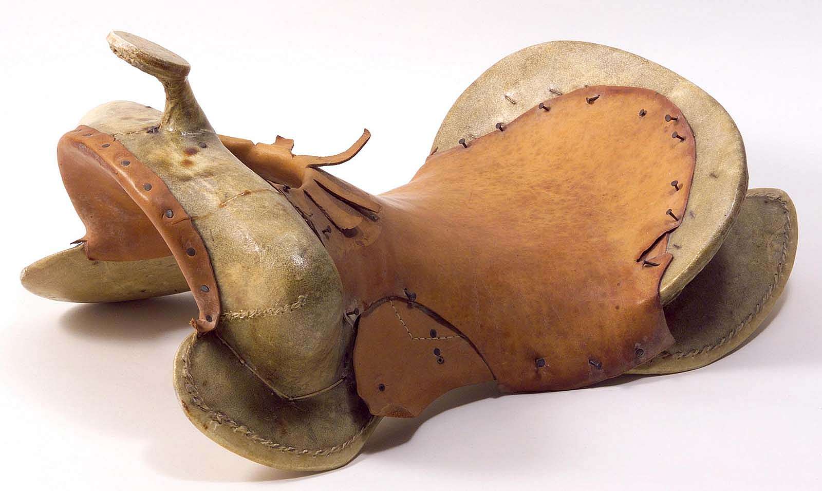 Rawhide-covered wooden saddle tree with leather seat and gullet nailed to the tree. 1.69.4820