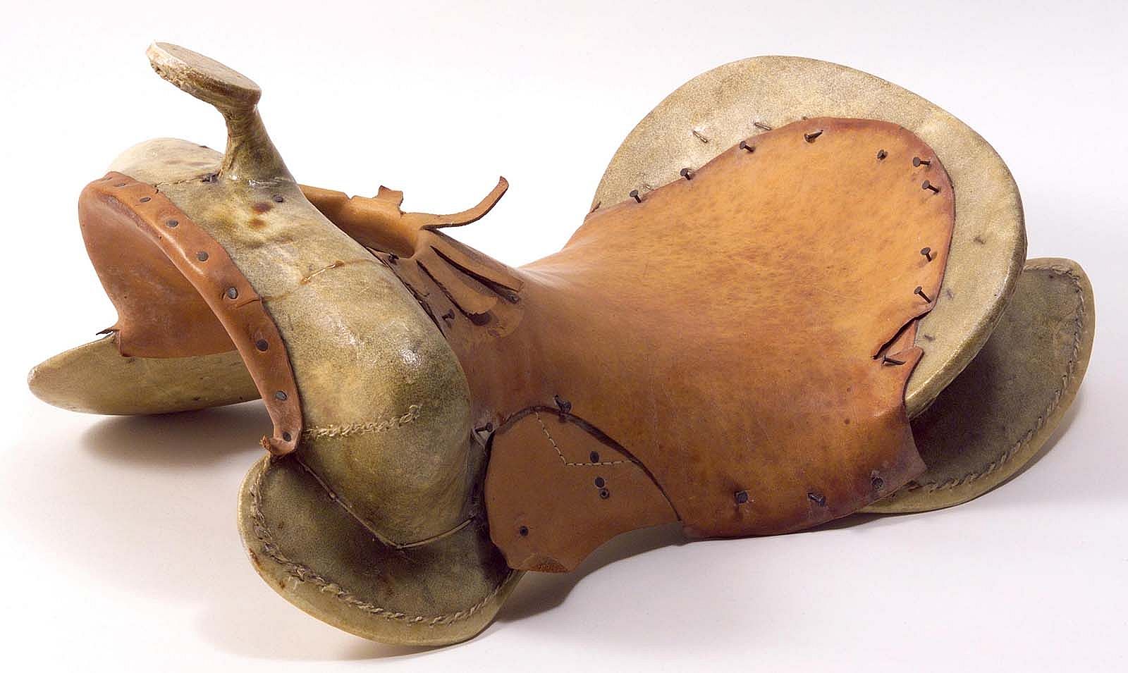 Rawhide-covered wooden saddle tree with leather seat and gullet nailed to the tree. 1.69.4820
