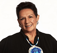 Headshot photo of women with short hair in black shirt with white and blue necklace.