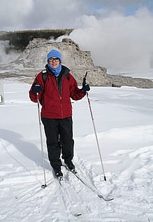 Nancy on skis in front of Castle Geyser, Old Faithful area in Yellowstone National Park
