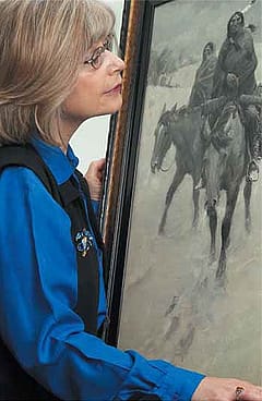 Story author Monique Westra studies the Glenbow's "Warriors'."